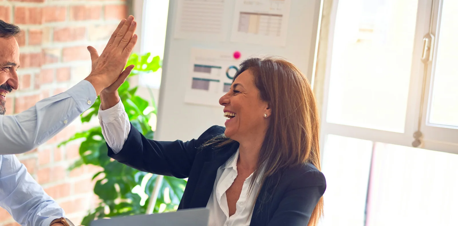 Empresaria latina celebrando resultados con su equipo de trabajo